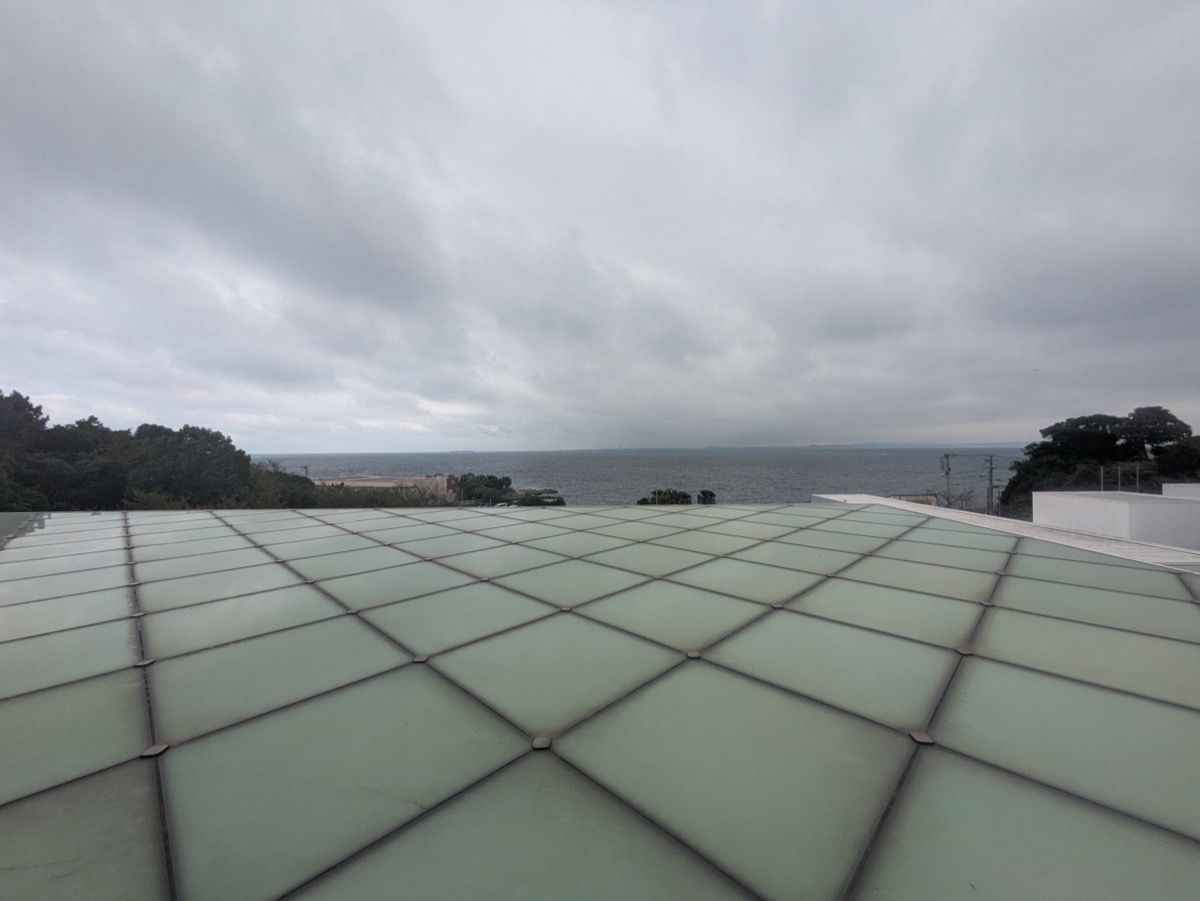 横須賀美術館の屋上にある半透明のパネル床。曇り空と海の景色が奥に広がる