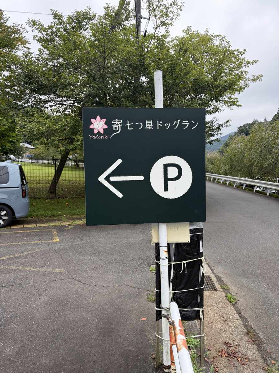 寄七つ星ドッグランの駐車場入口の看板。矢印でPの方向を示している