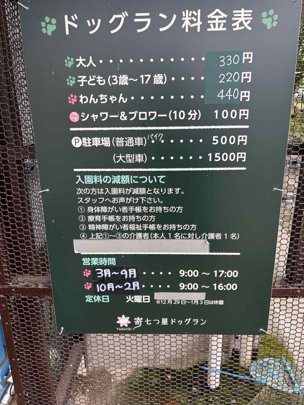 寄七つ星ドッグランの料金表看板。大人330円、子ども220円、わんちゃん440円、シャワー&ブロワー10分100円、駐車場普通車500円