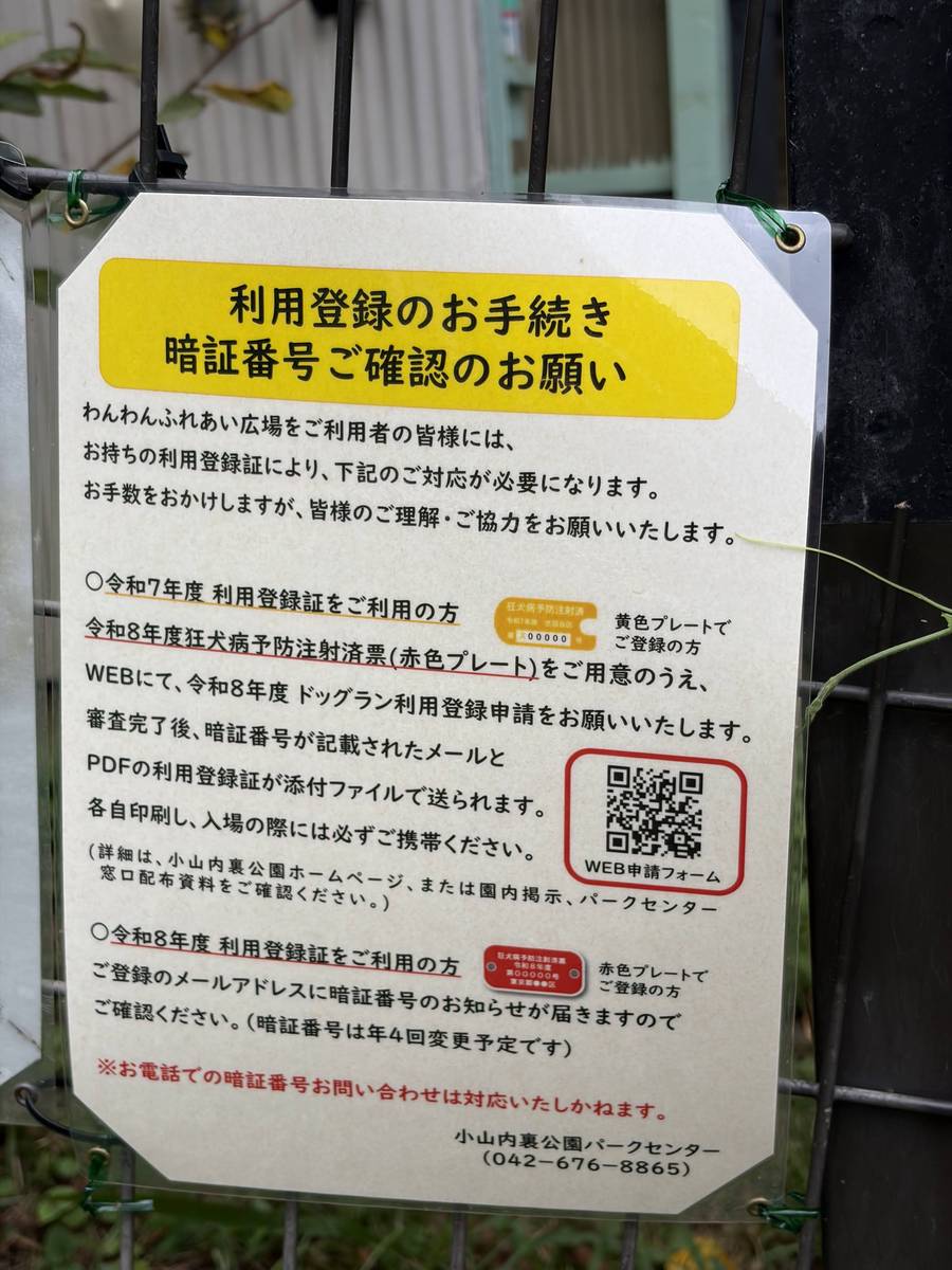 ドッグラン入口の掲示。利用登録の手続きと暗証番号確認のお願い、WEB申請フォームのQRコードが書かれている