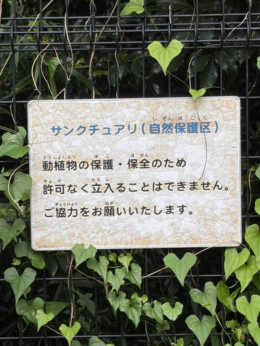 フェンスに掛かったサンクチュアリ（自然保護区）の掲示。動植物の保護・保全のため許可なく立ち入れないと書かれている