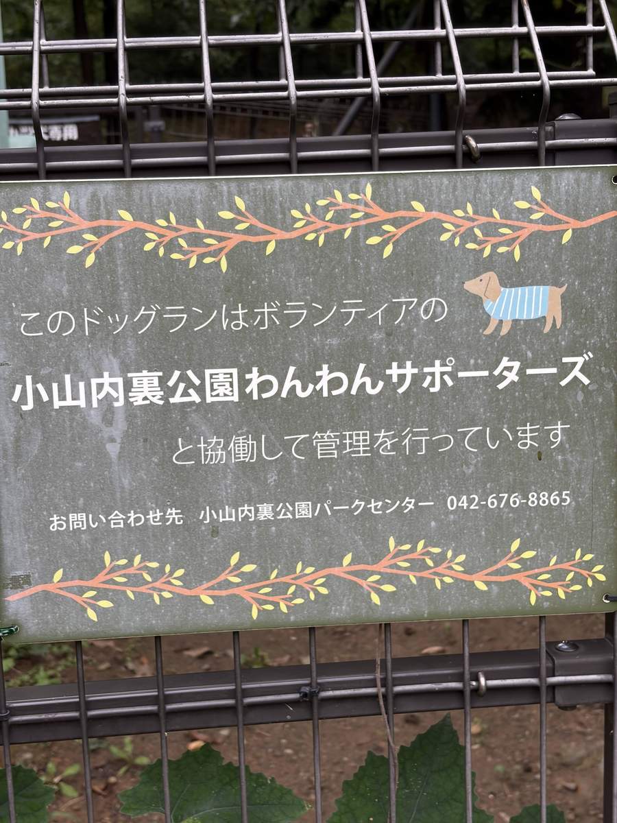 フェンスに掛かった看板。このドッグランはボランティアの小山内裏公園わんわんサポーターズと協働して管理していると書かれている