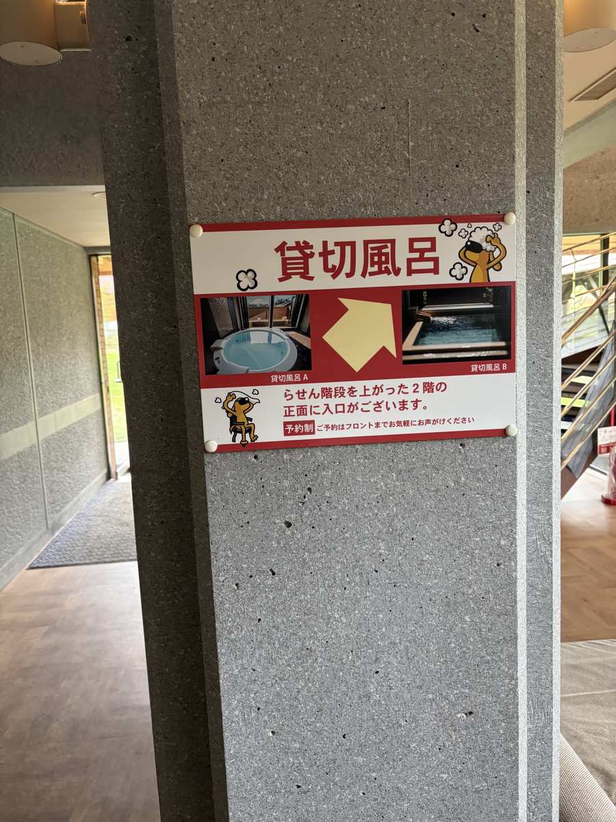 館内の柱に貼られた「貸切風呂」の案内板。らせん階段を上がった2階と書かれている