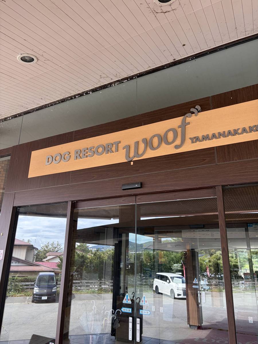 DOG RESORT woof YAMANAKAKOと書かれた入口の看板とガラスの自動ドア